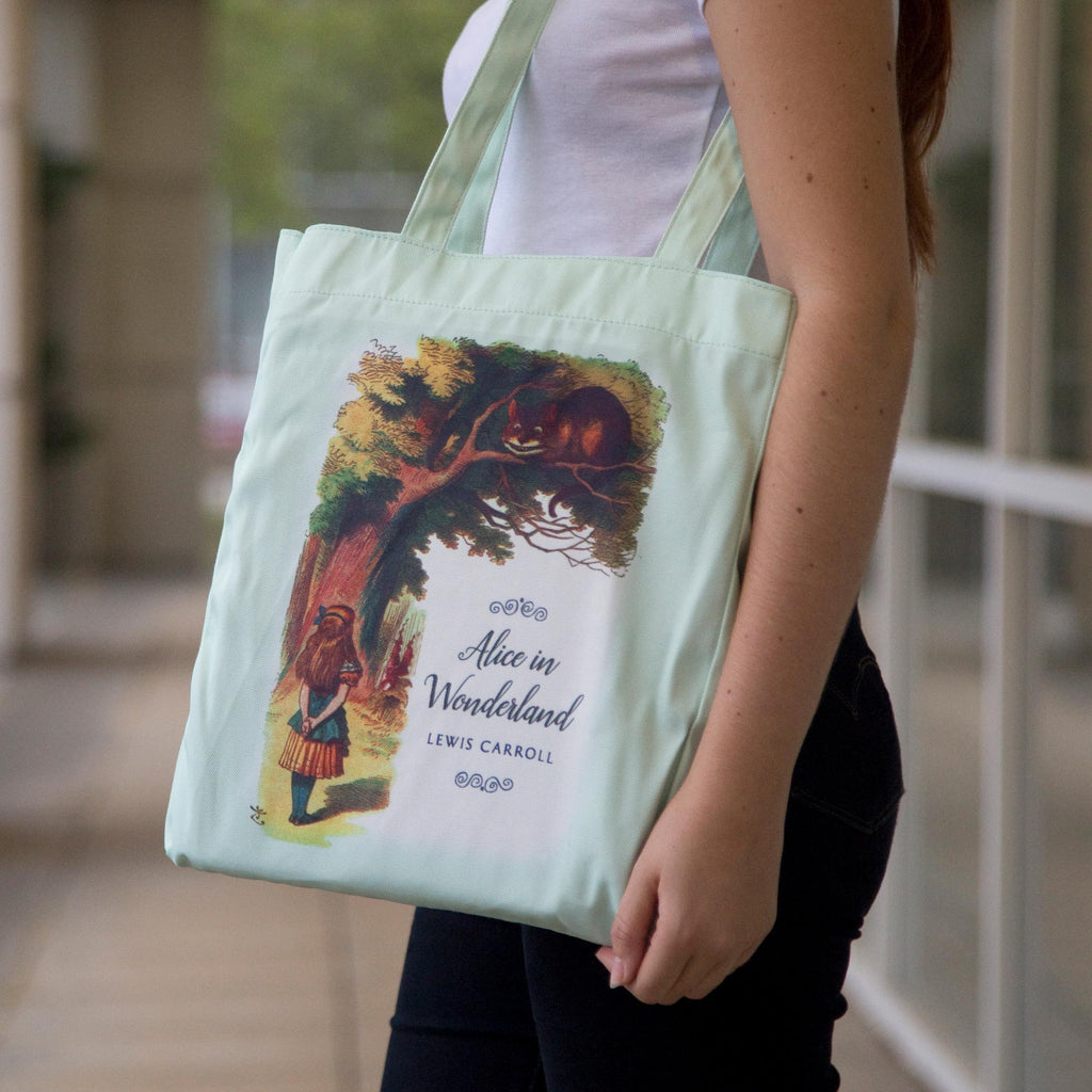 Alice's Adventures in Wonderland Green Tote Bag by Lewis Carroll featuring Alice and Cheshire Cat design, by Well Read Co. - Girl Standing