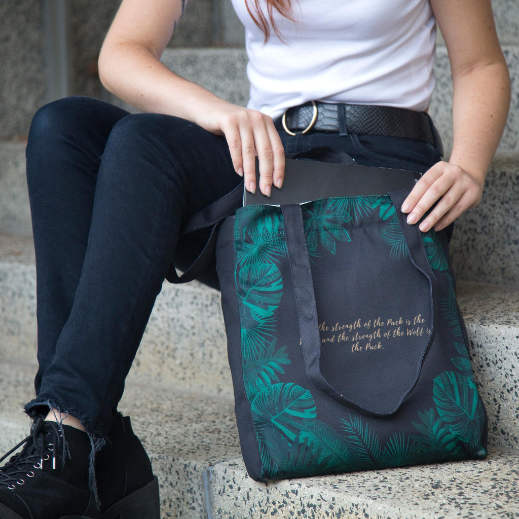 The Jungle Book Green Tote Bag by Rudyard Kipling featuring Jungle Leaves design, by Well Read Co. - Model Sitting with Bag