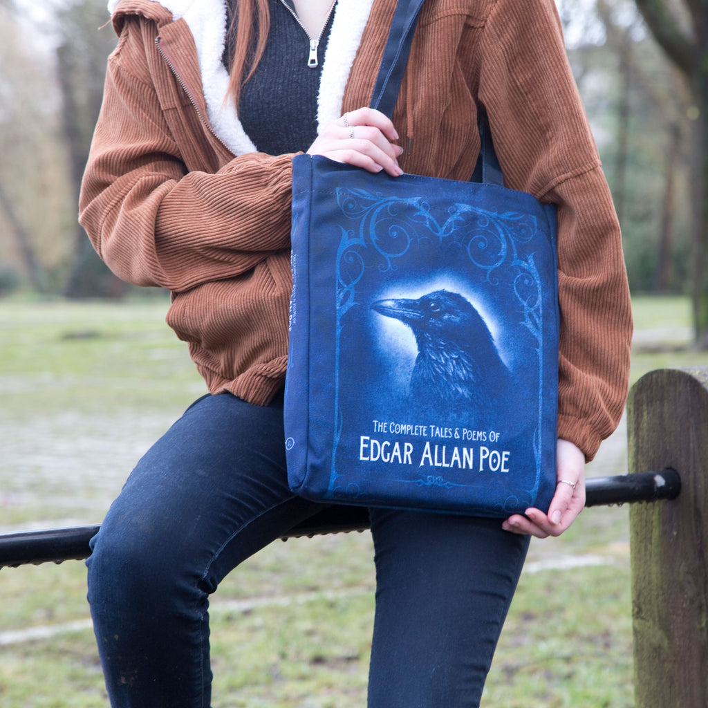 Collection of Tales and Poems Blue Tote Bag by Edgar Allen Poe featuring Raven design, by Well Read Co. - Model Sitting